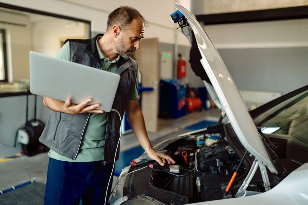 can you trade in a car with check engine light OBD-II scanner displaying a check engine code while a person explains the car’s issue to a potential buyer.
