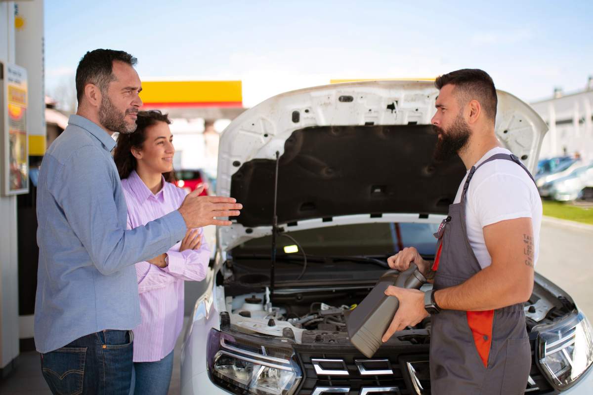 A car with the check engine light on being evaluated at a dealership for trade-in.