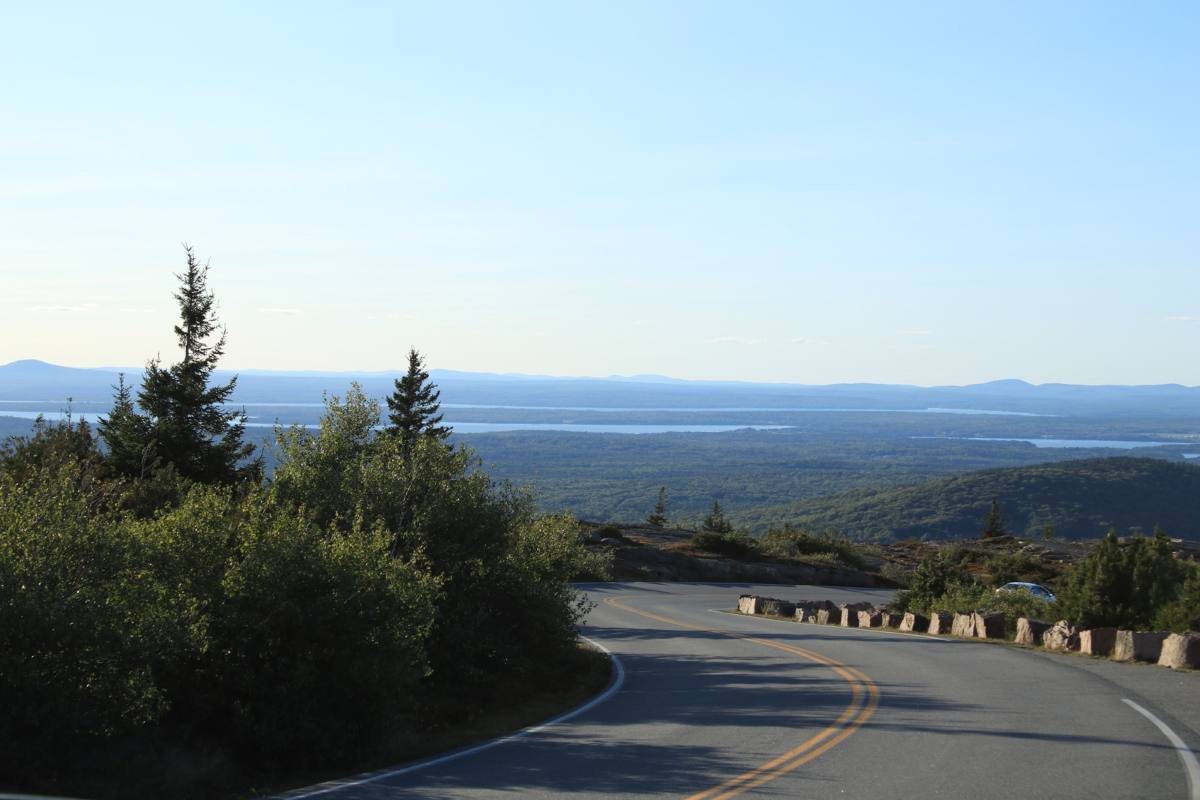 Car driving over a bumpy and sloped road, showing uneven surface and tires in motion.