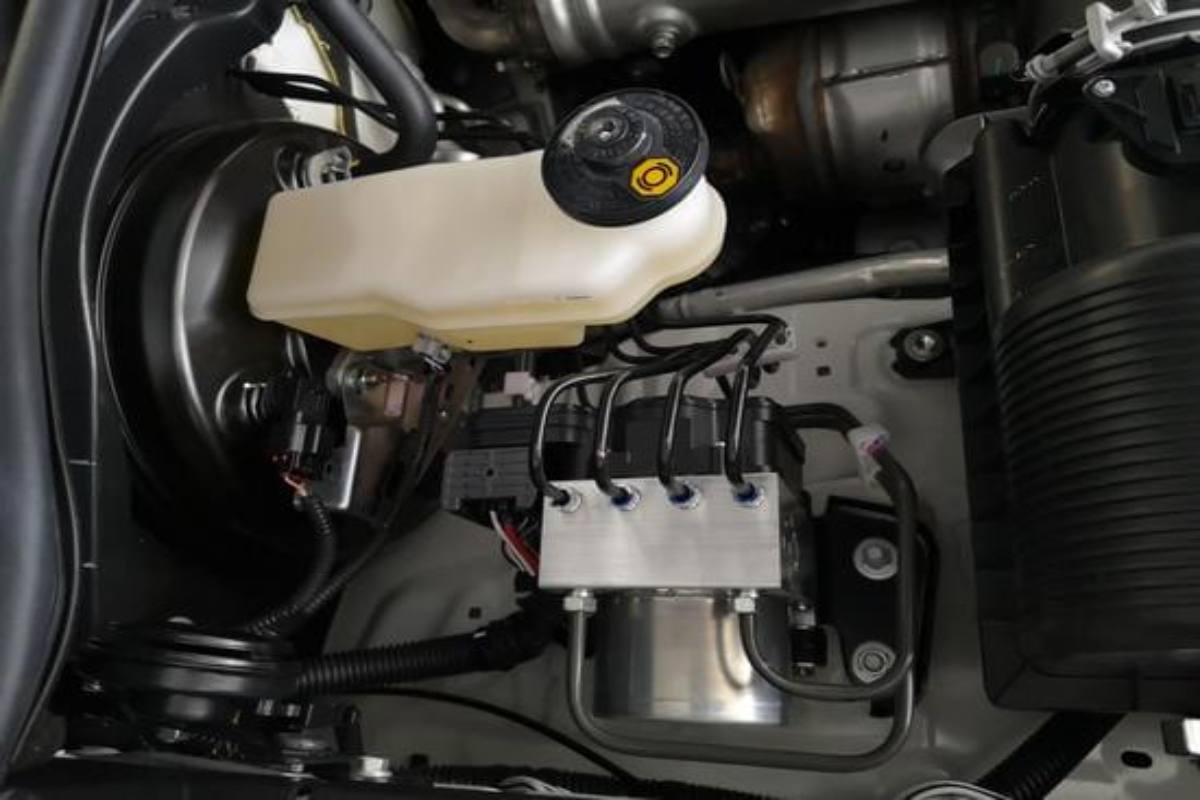 ABS brake system being checked while bleeding brake fluid with a clear tube.