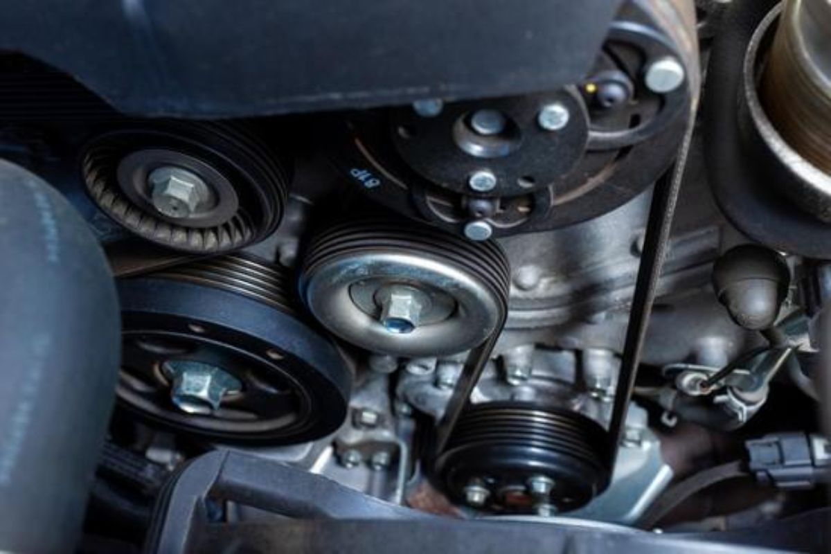Close-up of a worn or loose serpentine belt in a car engine.